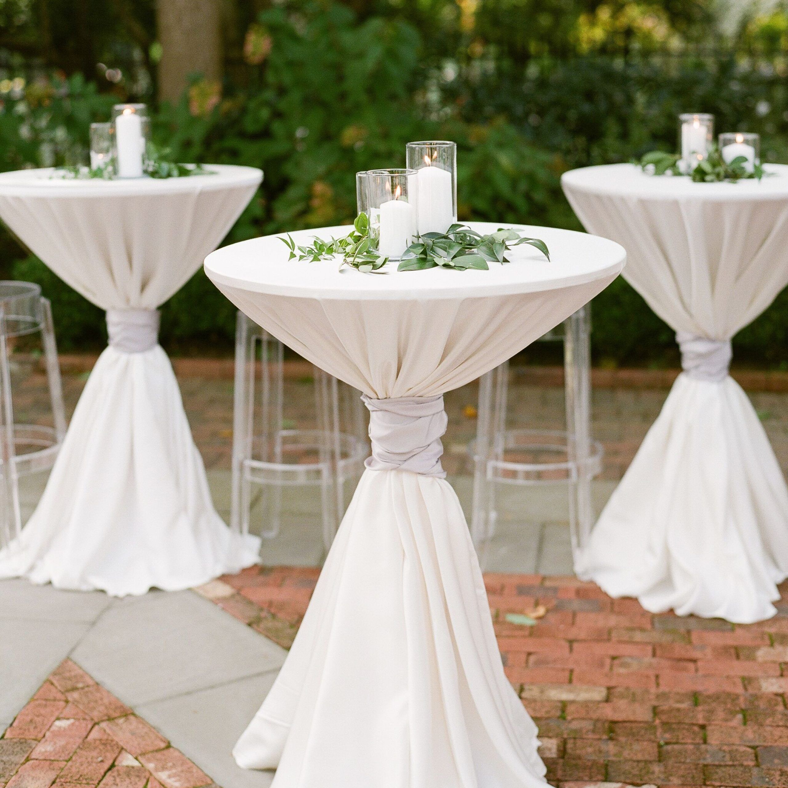 White Pillar Candles And Greenery Atop Cocktail Tables | Wedding With Regard To Natural Outdoor Cocktail Tables (View 7 of 20)